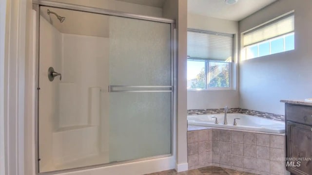 full bath with a garden tub, a shower stall, and vanity