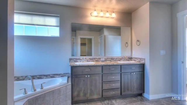 bathroom featuring a garden tub, double vanity, a sink, and decorative backsplash