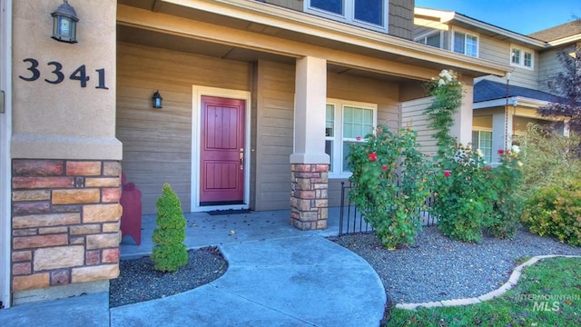 property entrance featuring covered porch and stone siding