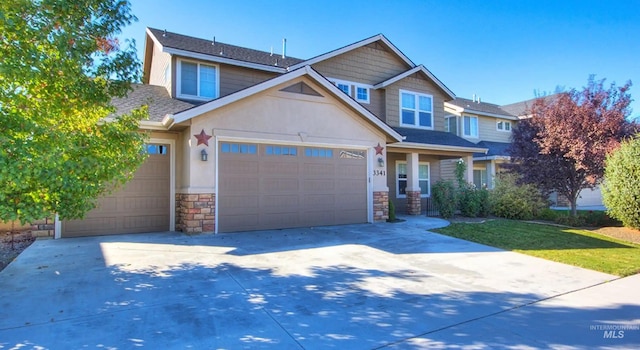 view of front of home with concrete driveway, stone siding, an attached garage, and stucco siding