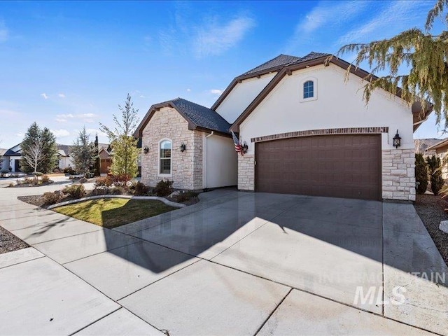 view of front facade with stone siding, stucco siding, driveway, and an attached garage