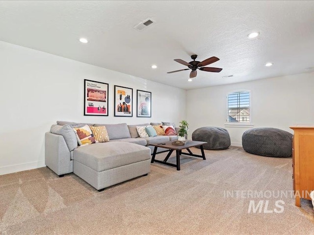 living room with visible vents, recessed lighting, a textured ceiling, and carpet