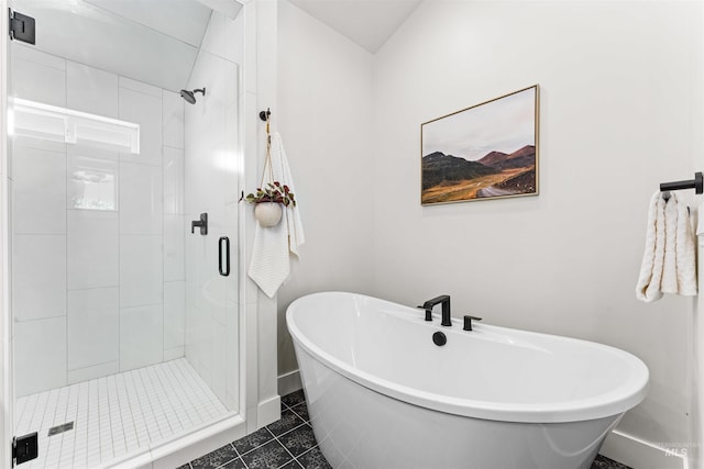 bathroom featuring a shower stall, tile patterned flooring, baseboards, and a freestanding tub