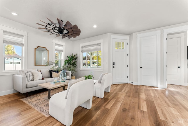living room with baseboards, light wood-type flooring, plenty of natural light, and recessed lighting