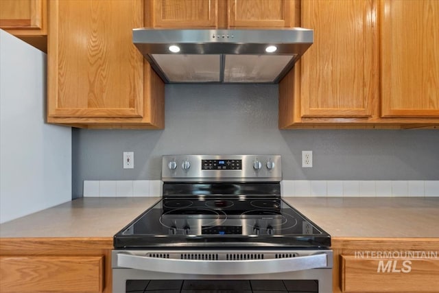1600 Peregrine, Mountain Home, ID 83647 - kitchen with stainless steel range with electric stovetop, under cabinet range hood, and light countertops