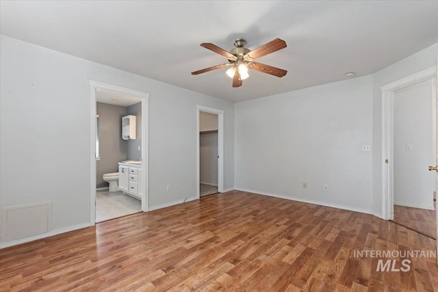 1600 Peregrine, Mountain Home, ID 83647 - unfurnished bedroom featuring light wood-type flooring, a walk in closet, connected bathroom, and baseboards