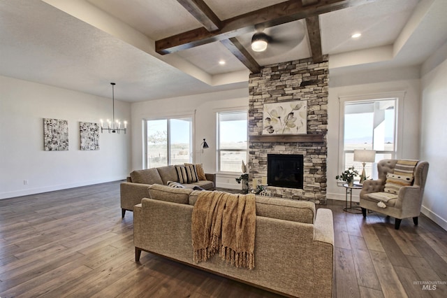 living room featuring beamed ceiling, a fireplace, dark hardwood / wood-style floors, and an inviting chandelier