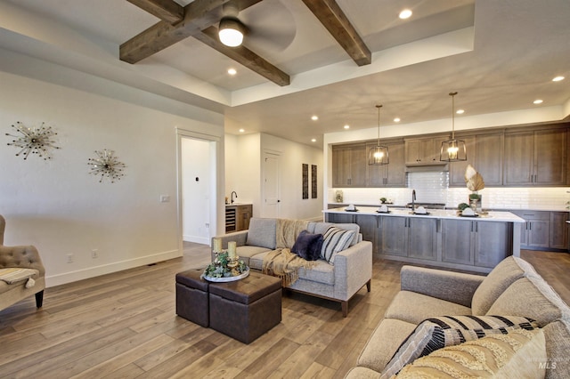 living room featuring beam ceiling, hardwood / wood-style flooring, and ceiling fan