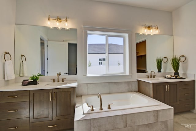 bathroom with vanity and tiled bath