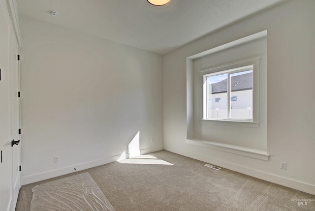 unfurnished room featuring light carpet