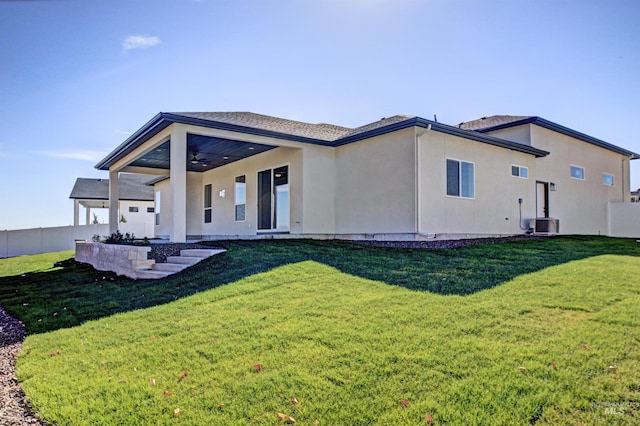 back of house featuring central air condition unit, ceiling fan, and a lawn