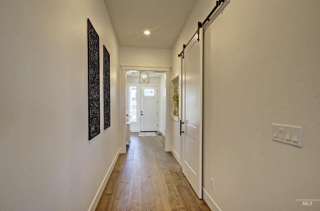 hall featuring hardwood / wood-style flooring and a barn door