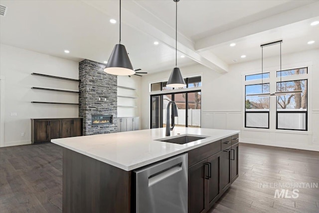 kitchen with a fireplace, a sink, dark wood-style floors, dishwasher, and beamed ceiling