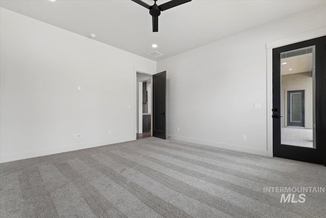 carpeted spare room featuring recessed lighting, visible vents, and baseboards