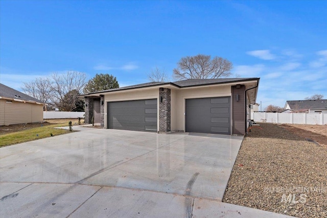 garage with fence and concrete driveway