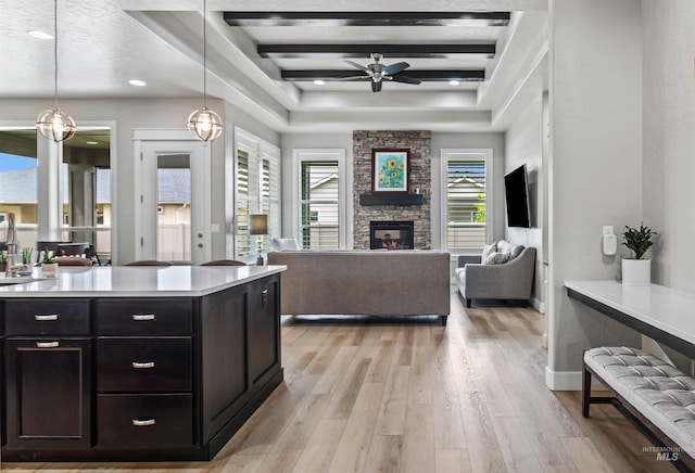 18279 N Tulip Ave, Nampa, ID 83687 - kitchen featuring a ceiling fan, a fireplace, light countertops, open floor plan, and light wood-style flooring