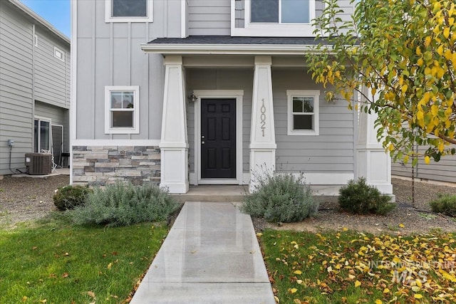 doorway to property with cooling unit and a porch