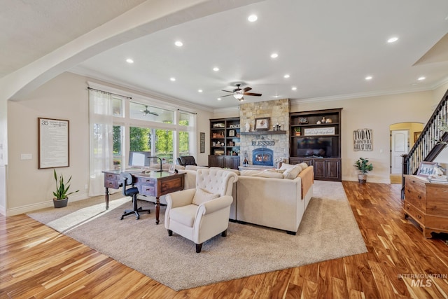 2466 Brooks Dr, Fruitland, ID 83619 - living room featuring arched walkways, a ceiling fan, ornamental molding, light wood-style floors, and baseboards
