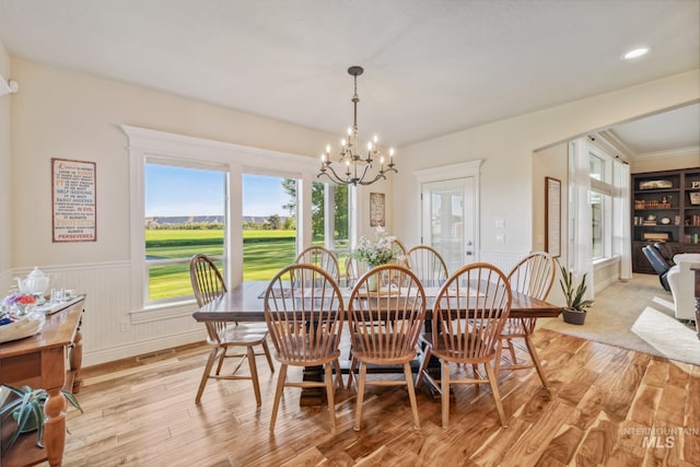 2466 Brooks Dr, Fruitland, ID 83619 - dining area featuring a chandelier, light wood-type flooring, wainscoting, and healthy amount of natural light