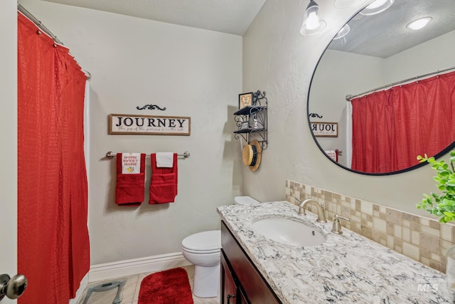 2466 Brooks Dr, Fruitland, ID 83619 - bathroom featuring tasteful backsplash, vanity, toilet, baseboards, and tile patterned flooring