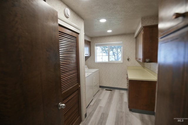 8395 W Golse Dr, Boise, ID 83704 - clothes washing area featuring washer and dryer, light wood-style flooring, cabinet space, wallpapered walls, and a textured ceiling