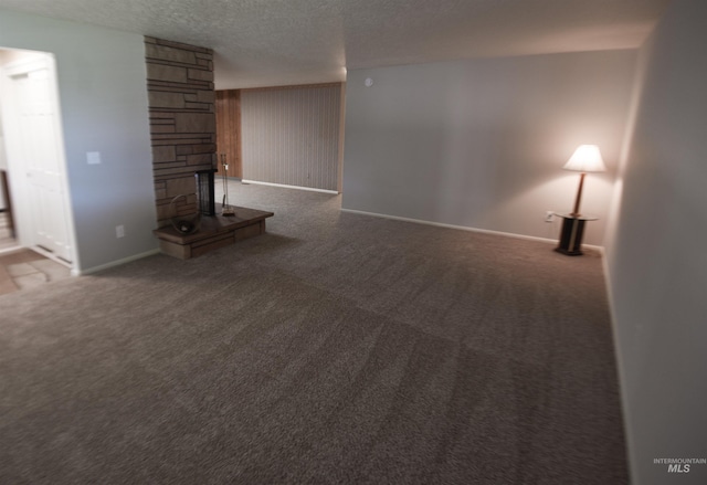 8395 W Golse Dr, Boise, ID 83704 - unfurnished living room featuring a textured ceiling, carpet flooring, baseboards, and a stone fireplace