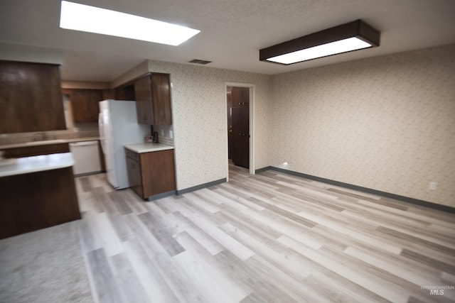 8395 W Golse Dr, Boise, ID 83704 - kitchen featuring wallpapered walls, visible vents, white appliances, light countertops, and light wood-style floors
