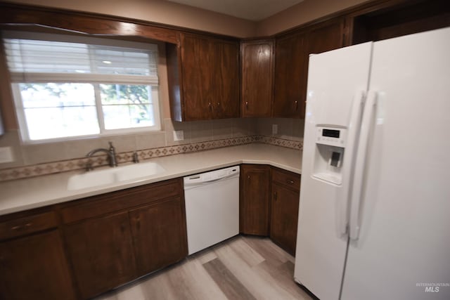 8395 W Golse Dr, Boise, ID 83704 - kitchen with a sink, white appliances, light wood-style flooring, backsplash, and light countertops