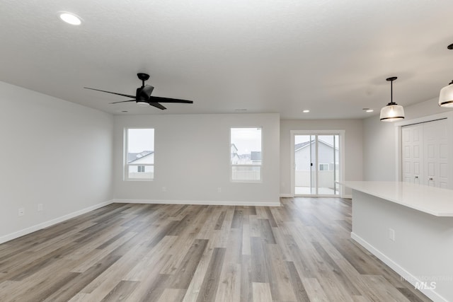 unfurnished living room with light wood finished floors, baseboards, and recessed lighting