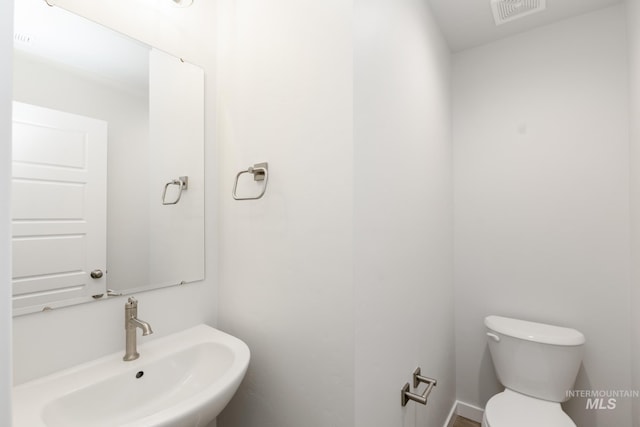 bathroom featuring visible vents, a sink, and toilet