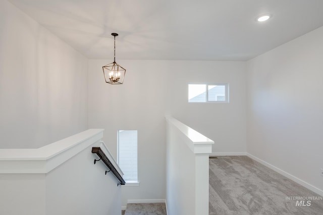 stairs featuring a chandelier and light carpet