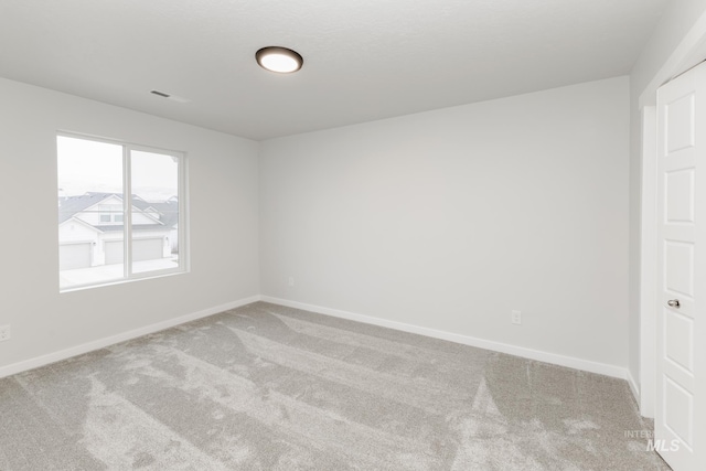 spare room with carpet and baseboards