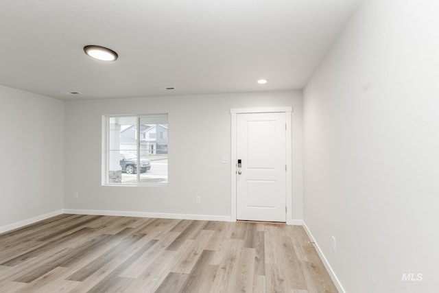 spare room featuring light wood-style floors, recessed lighting, visible vents, and baseboards