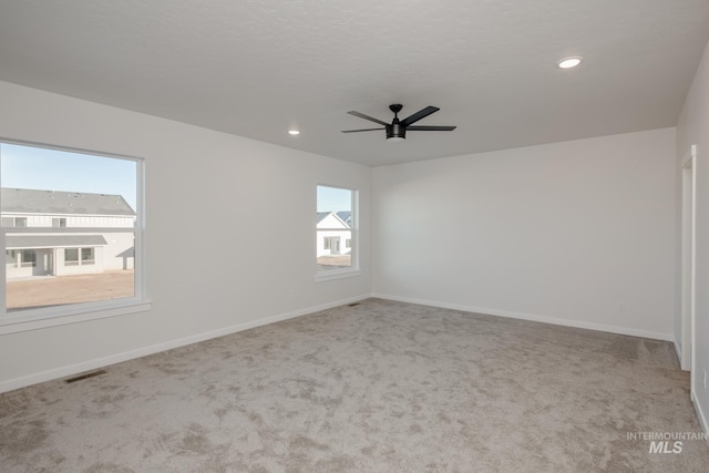 carpeted empty room featuring ceiling fan