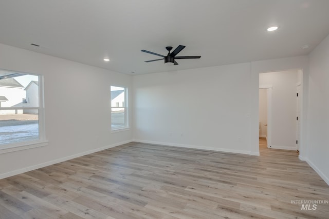 spare room with ceiling fan, plenty of natural light, and light hardwood / wood-style flooring