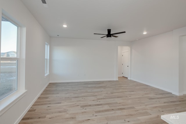 spare room with ceiling fan, a wealth of natural light, and light hardwood / wood-style floors