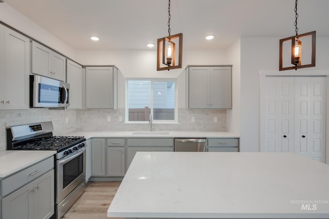 kitchen featuring gray cabinets, appliances with stainless steel finishes, sink, and light hardwood / wood-style floors