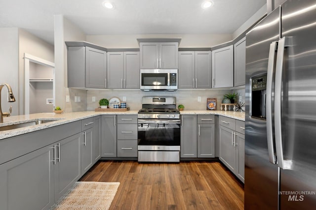 6303 W Stavros Dr, Meridian, ID 83646 - kitchen featuring appliances with stainless steel finishes, gray cabinetry, tasteful backsplash, dark wood-type flooring, and recessed lighting