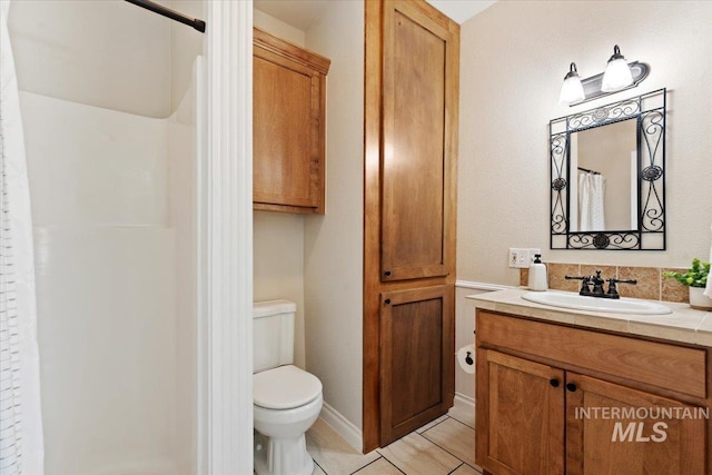 bathroom with vanity, tile patterned flooring, toilet, and curtained shower