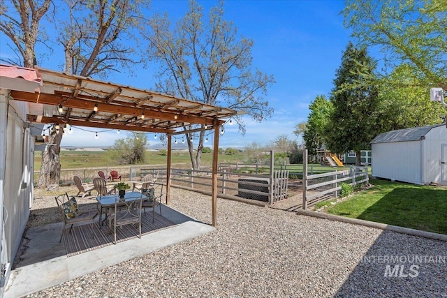 view of yard with outdoor dining area, an outdoor structure, and a storage unit