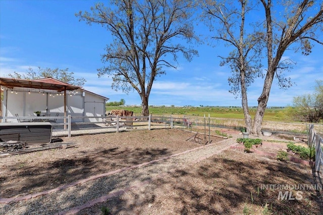 view of yard with an exterior structure, a rural view, and an outdoor structure
