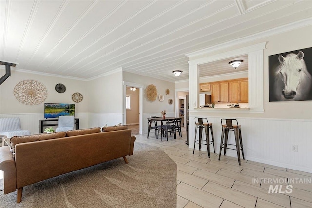living room featuring ornamental molding and wainscoting