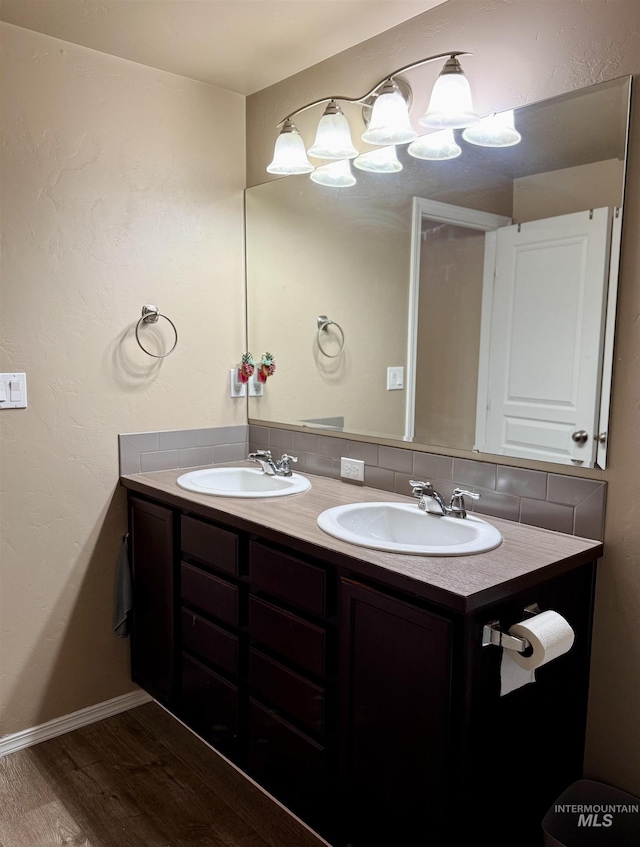 bathroom featuring vanity, wood-type flooring, and backsplash