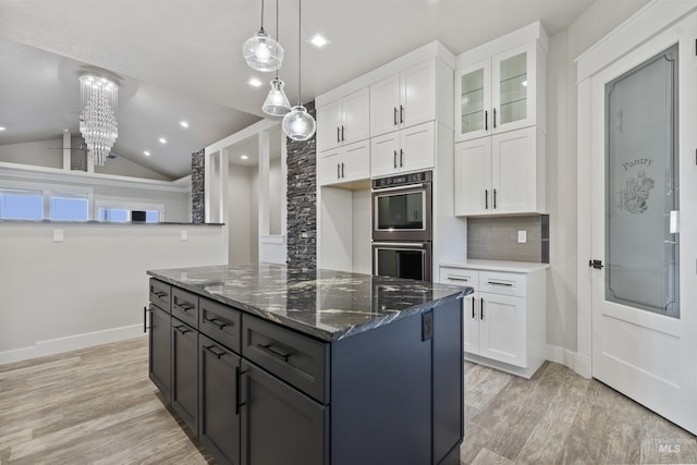 5990 W View Dr, Meridian, ID 83642 - kitchen with double oven, white cabinetry, dark stone countertops, a center island, and light wood finished floors