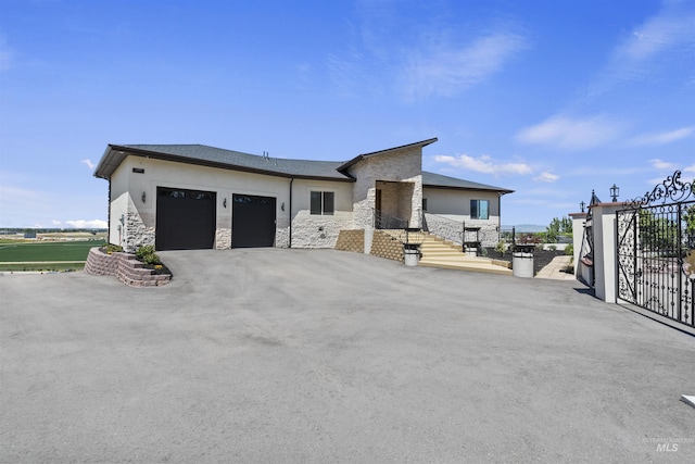 5990 W View Dr, Meridian, ID 83642 - view of front of property with an attached garage, stone siding, stucco siding, and driveway