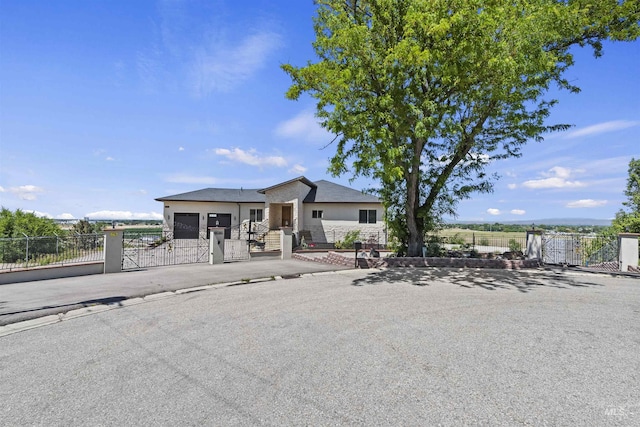 5990 W View Dr, Meridian, ID 83642 - view of front of house with a gate, a garage, stucco siding, a fenced front yard, and driveway
