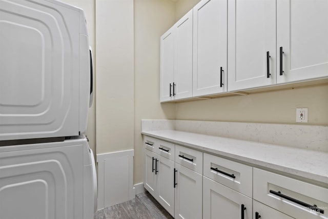 5990 W View Dr, Meridian, ID 83642 - washroom featuring stacked washer / dryer, cabinet space, wood finished floors, and wainscoting