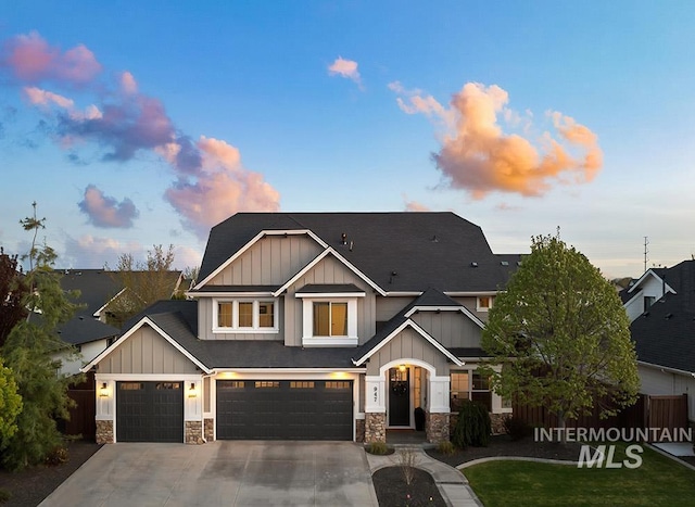 craftsman-style house with concrete driveway, stone siding, board and batten siding, and a garage