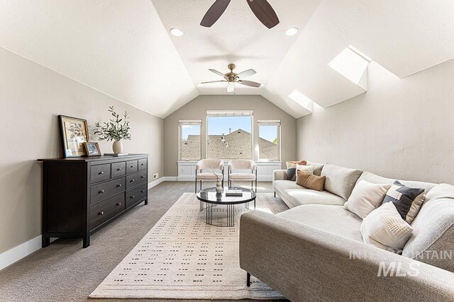 living room with lofted ceiling, baseboards, a ceiling fan, and carpet flooring