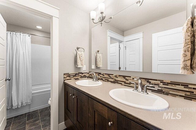 bathroom with decorative backsplash, a sink, and double vanity